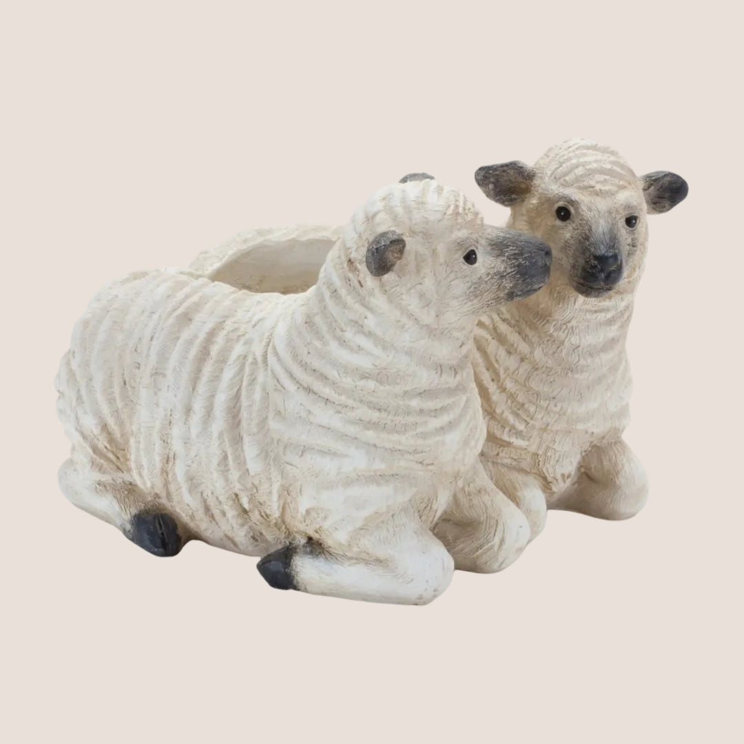 Two sheep-shaped planters on a white background