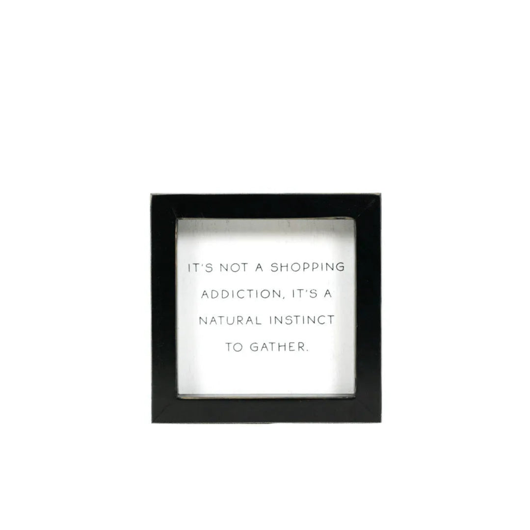 Black-framed wall art with white text on a white background