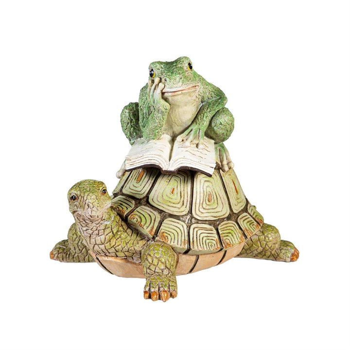 Statue of a frog on a turtle with a book, on a white background