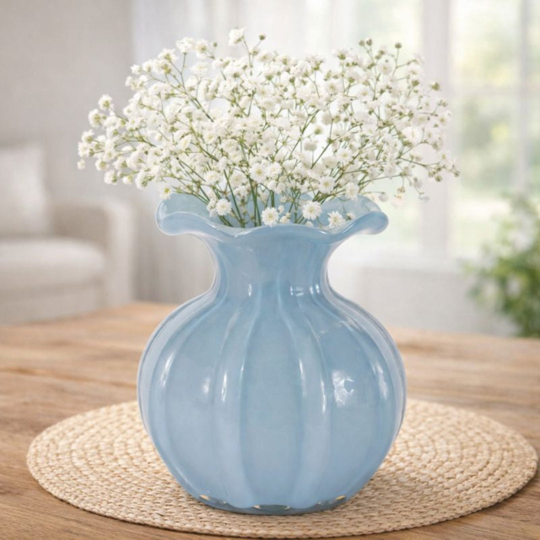 Blue vase with white flowers on a wooden table