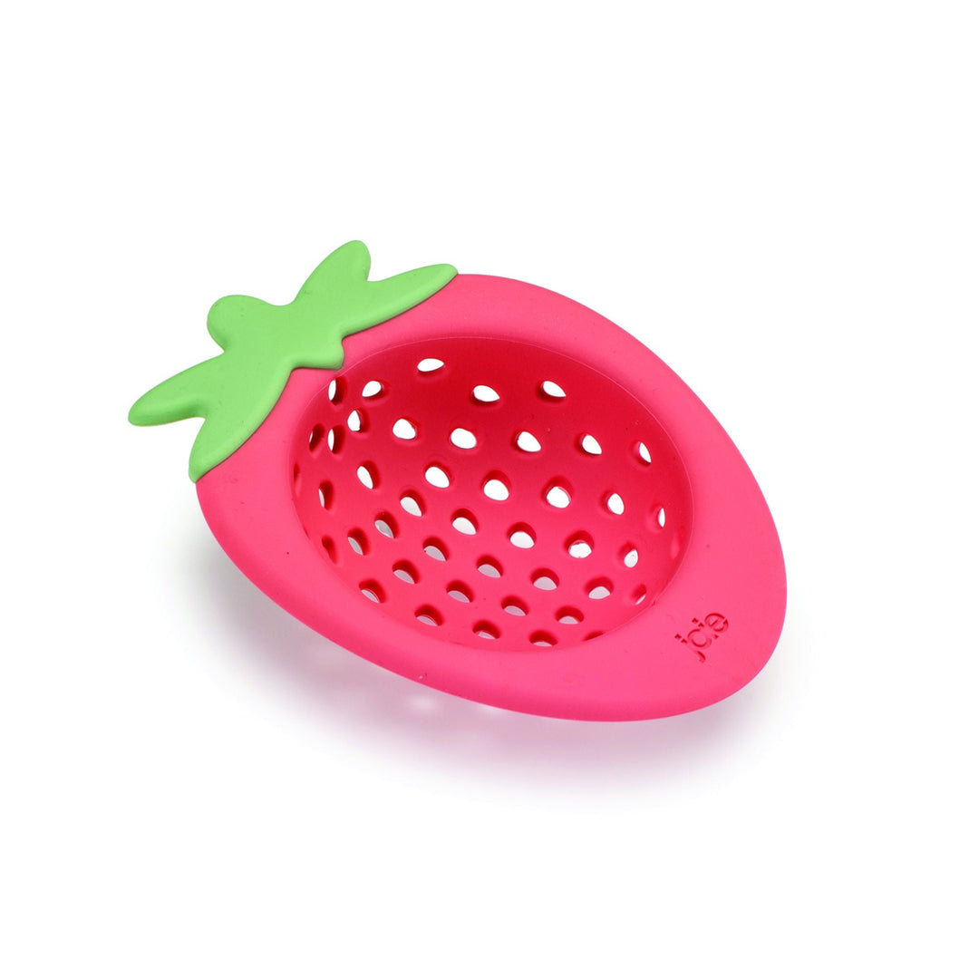 A strawberry-shaped pink silicone strainer with a green leafy top, shown on a clean white background.