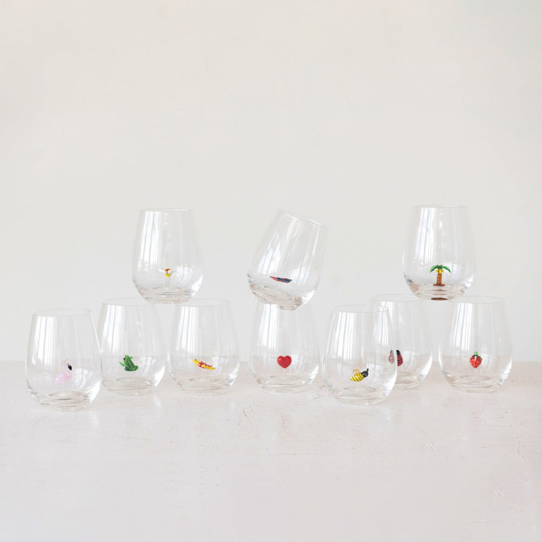 Set of clear glasses with small decorative items on a white background