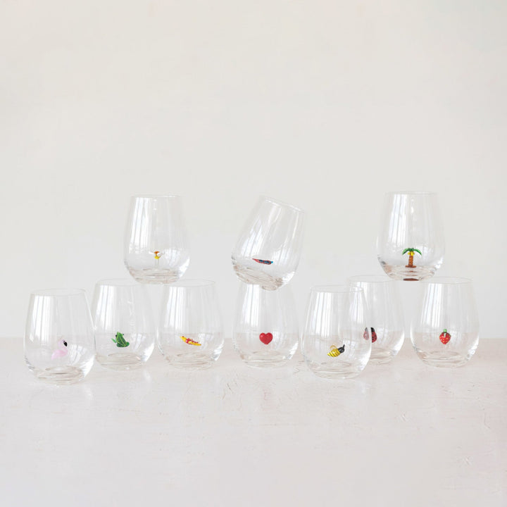 Set of clear glasses with small decorative items on a white background