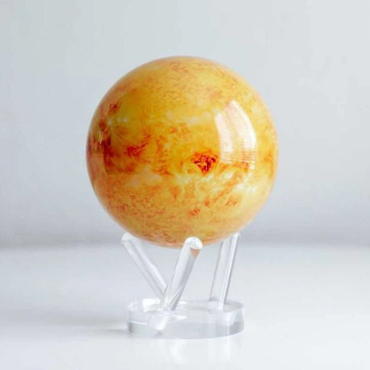 Model of a planet on a clear stand against a white background