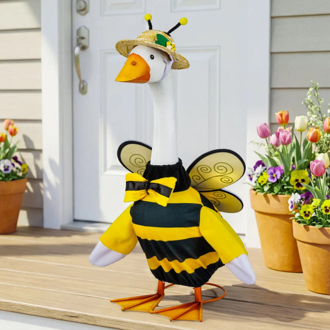 Goose wearing a bee costume on a porch with flowers