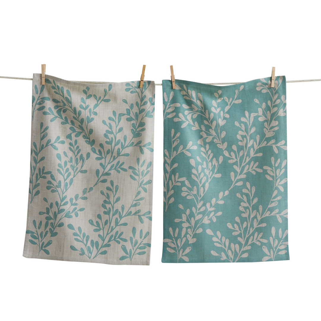 Two patterned towels hanging on a clothesline with a white background