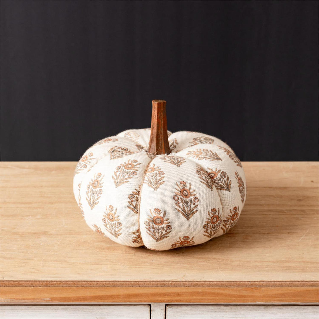 Decorative pumpkin with floral pattern on a wooden surface
