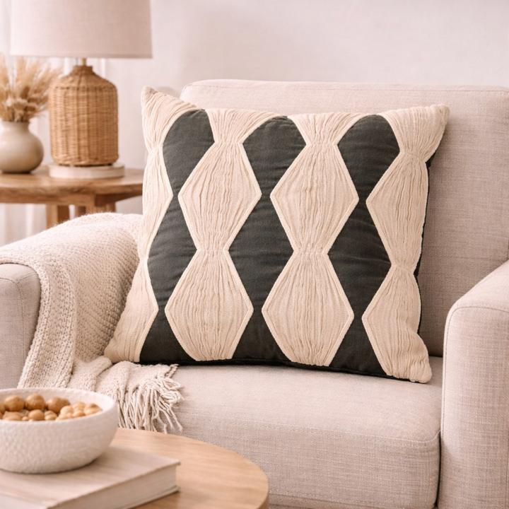 Decorative pillow with geometric pattern on a beige sofa in a cozy living room.