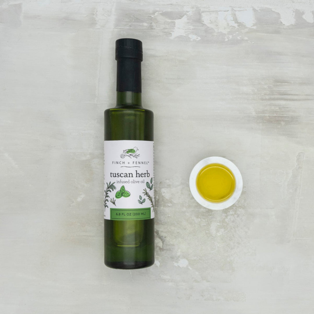 Bottle of Tuscan Herb olive oil with a dropper on a light gray background