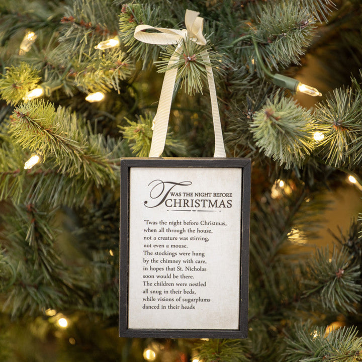 Decorative sign with 'Twas the Night Before Christmas' text hanging on a Christmas tree.