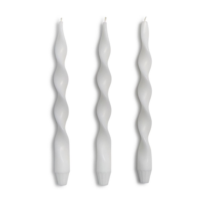 Three white twisted candles on a white background