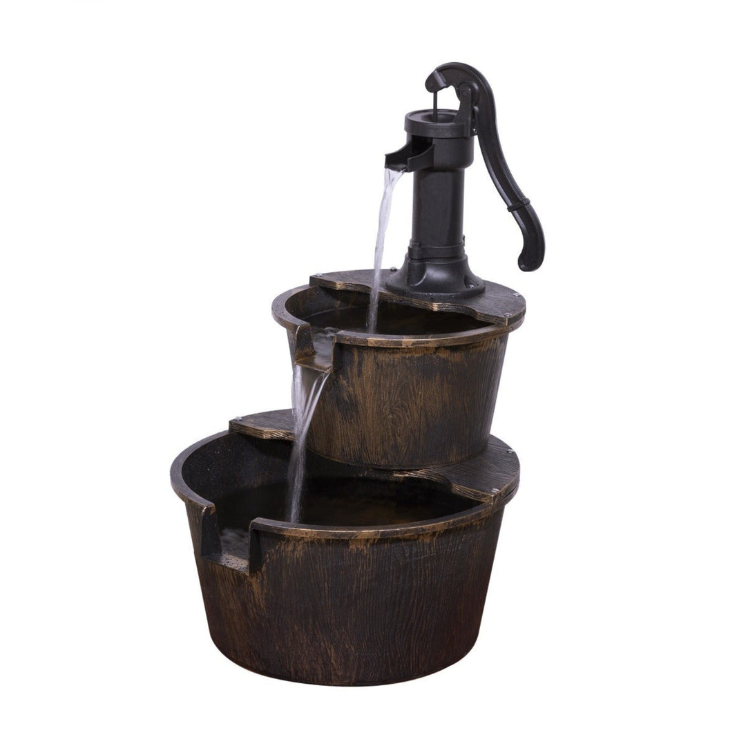 A two-tiered barrel pump fountain with water flowing from the pump into the barrel tiers, featuring a rustic look with a black pump and brown barrel.