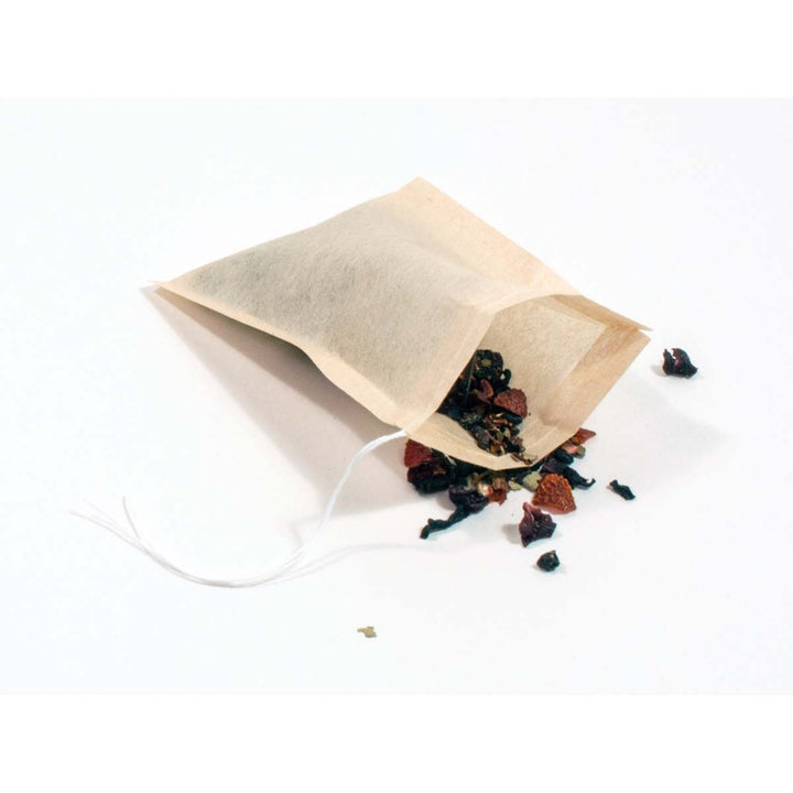 Tea bag with loose tea leaves on a white background