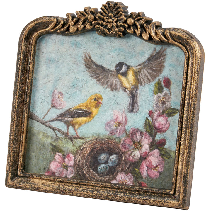 Decorative frame with birds, flowers, and a nest on a blue background