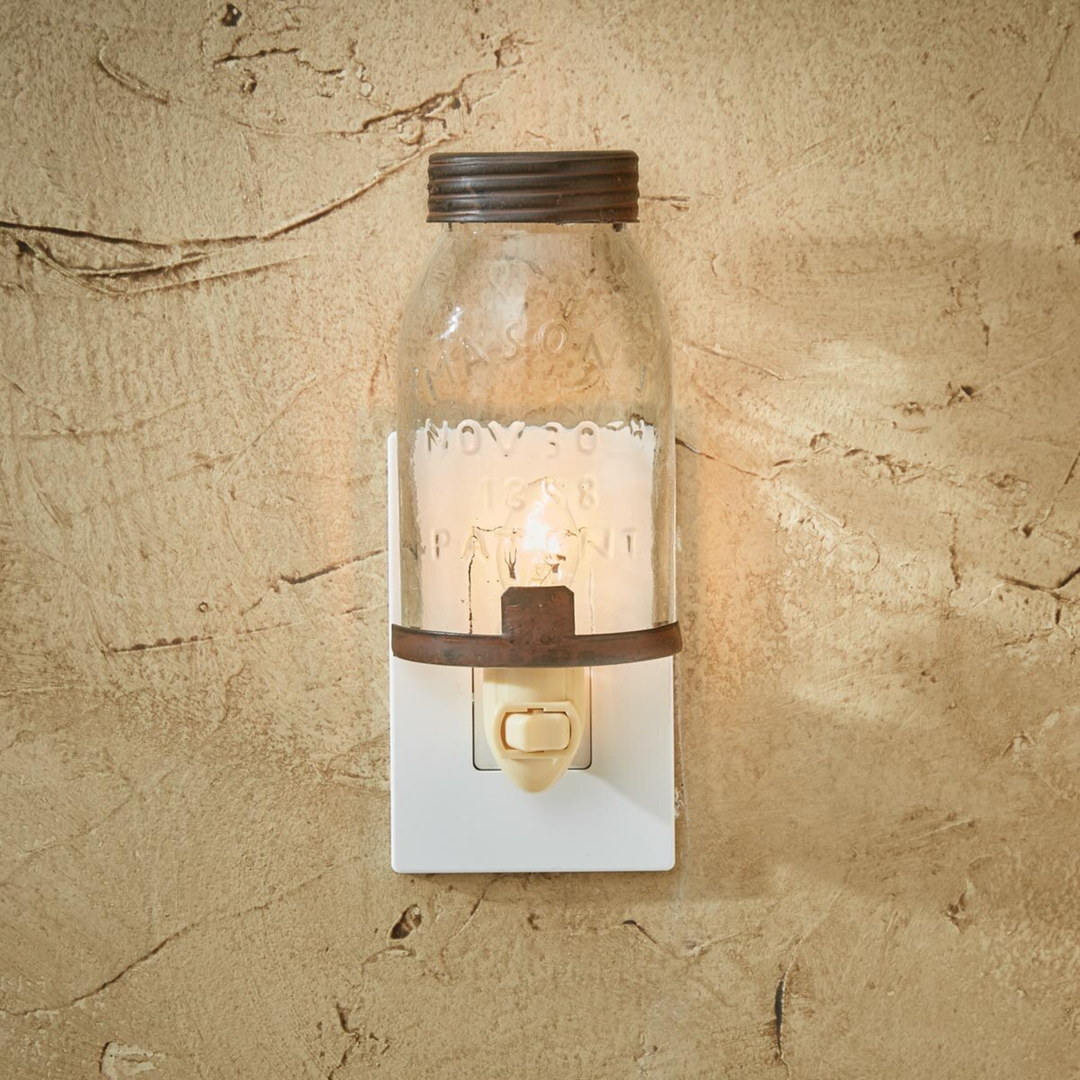 Decorative wall light fixture made from a glass bottle on a textured beige wall.