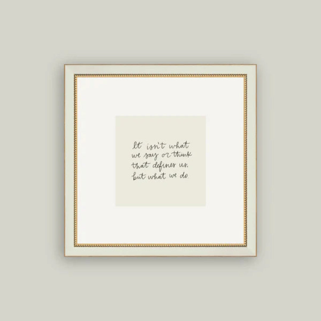 Framed print with a motivational quote on a plain wall