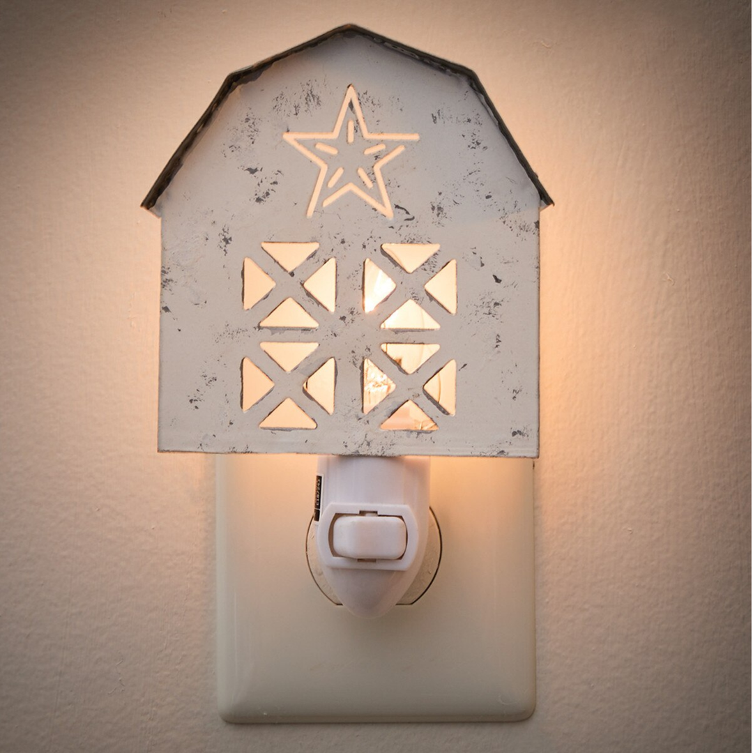 Decorative night light with star and geometric patterns on a beige wall.