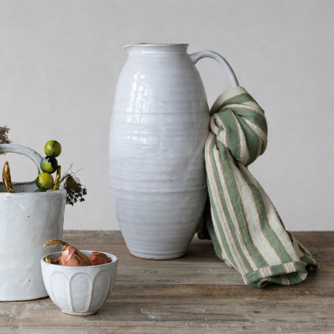 White Glazed Slim Stoneware Pitcher on wooden table with dishes on the side