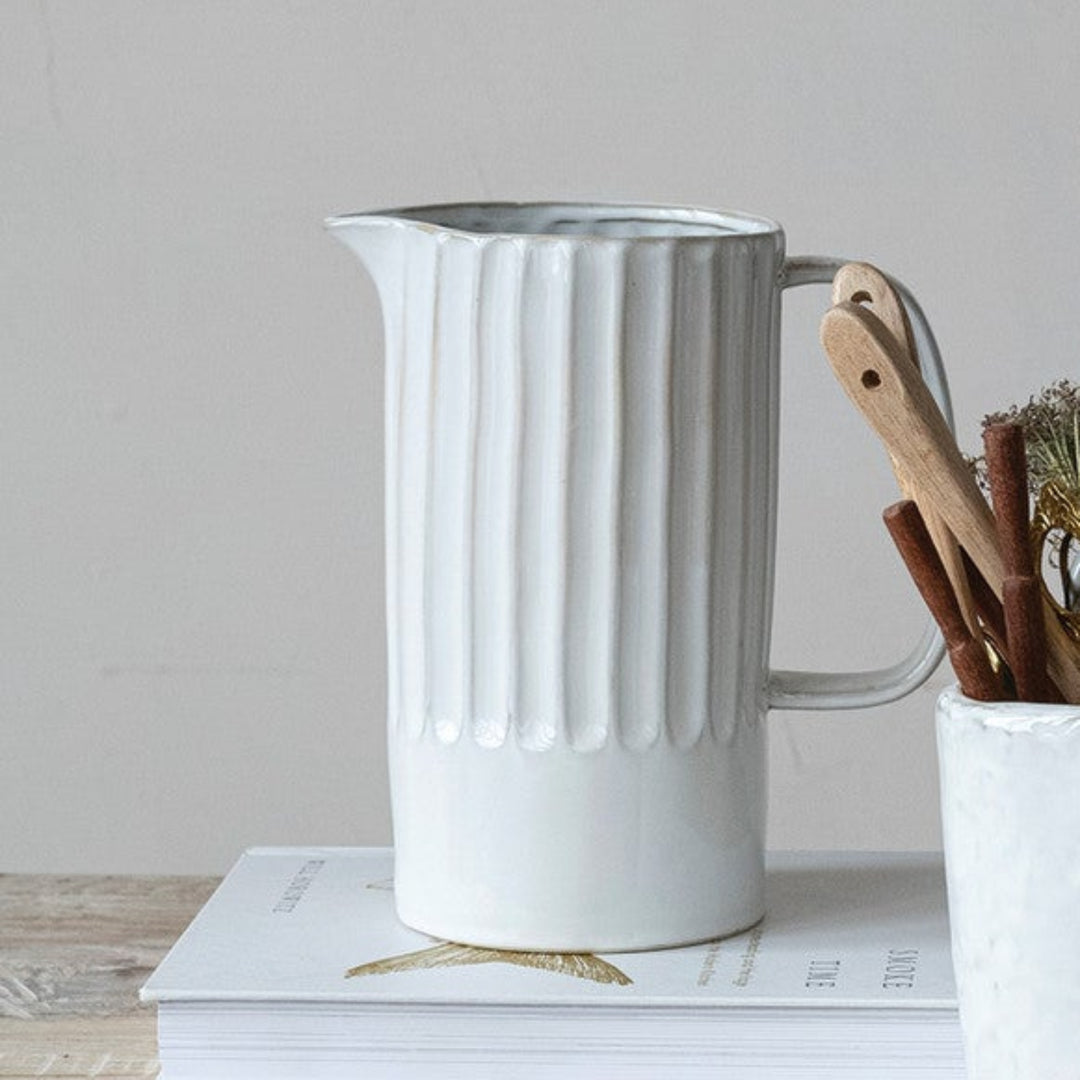 Set of ceramic pots and vases on a wooden surface with a neutral background
