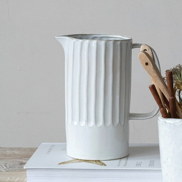Set of ceramic pots and vases on a wooden surface with a neutral background
