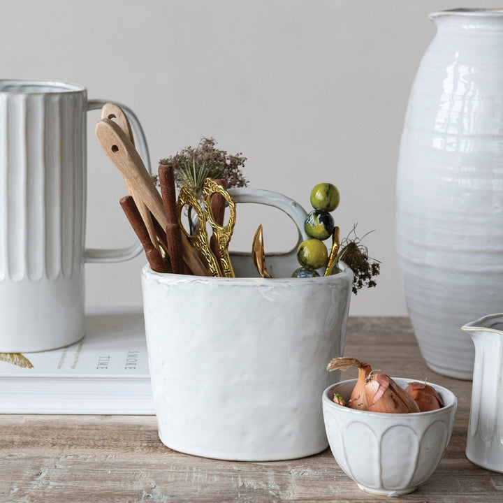 White ceramic container with kitchen utensils on a wooden surface