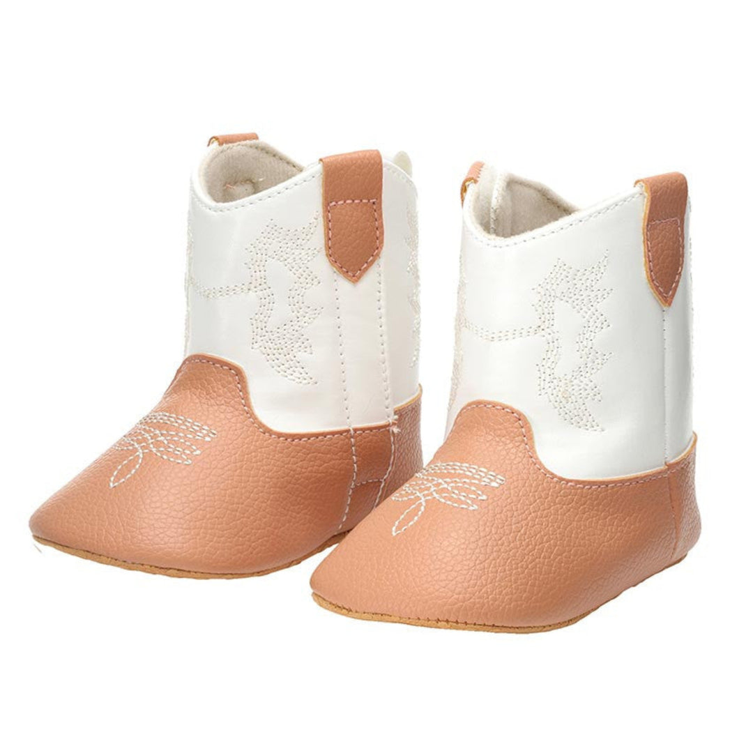 A pair of toddler western-style boots in white and tan faux leather, featuring white embroidered stitching on the shafts and toes.