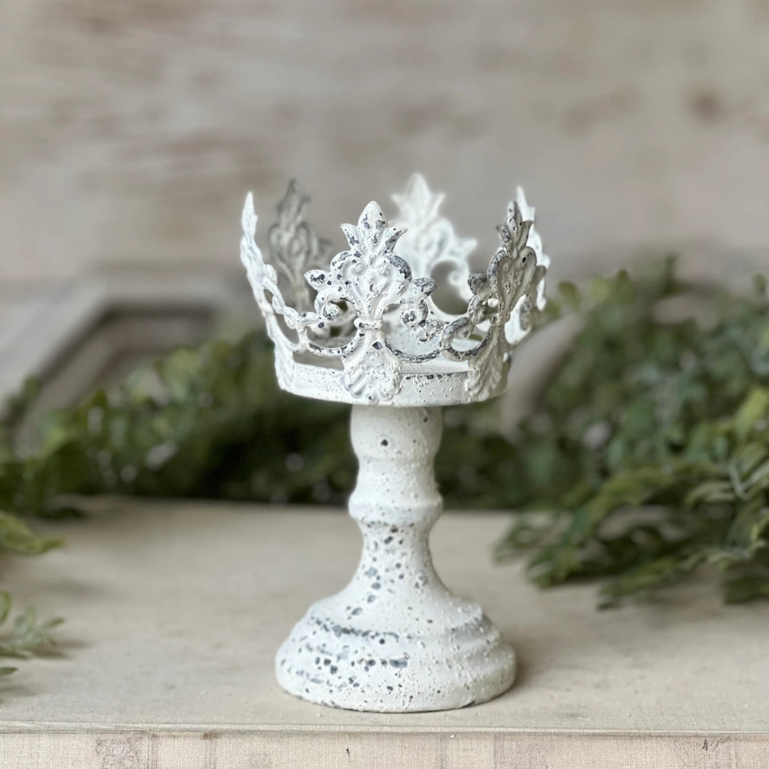 Decorative white crown on a stand with a neutral background