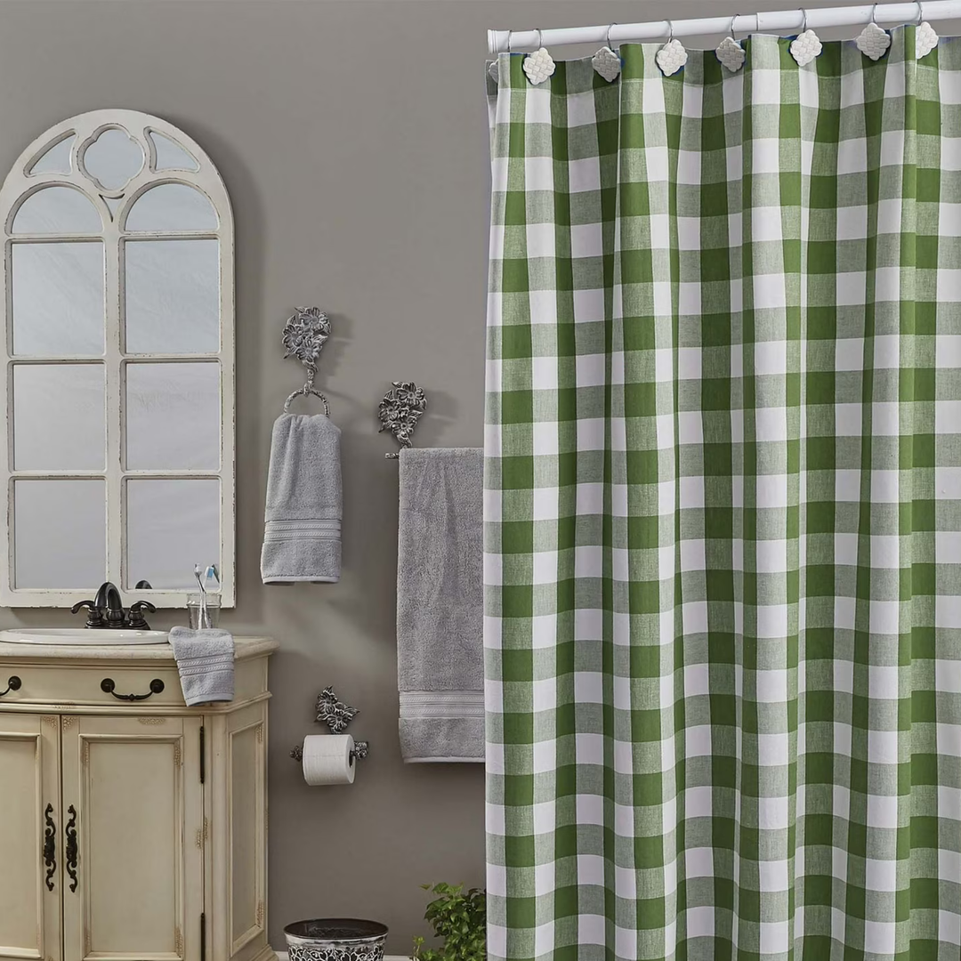 Bathroom with a green and white checkered shower curtain, sink, mirror, and towels.