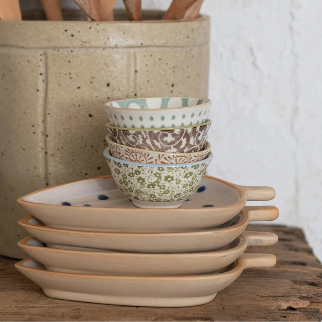 Kitchen utensils and bowls on a wooden surface with a white wall background