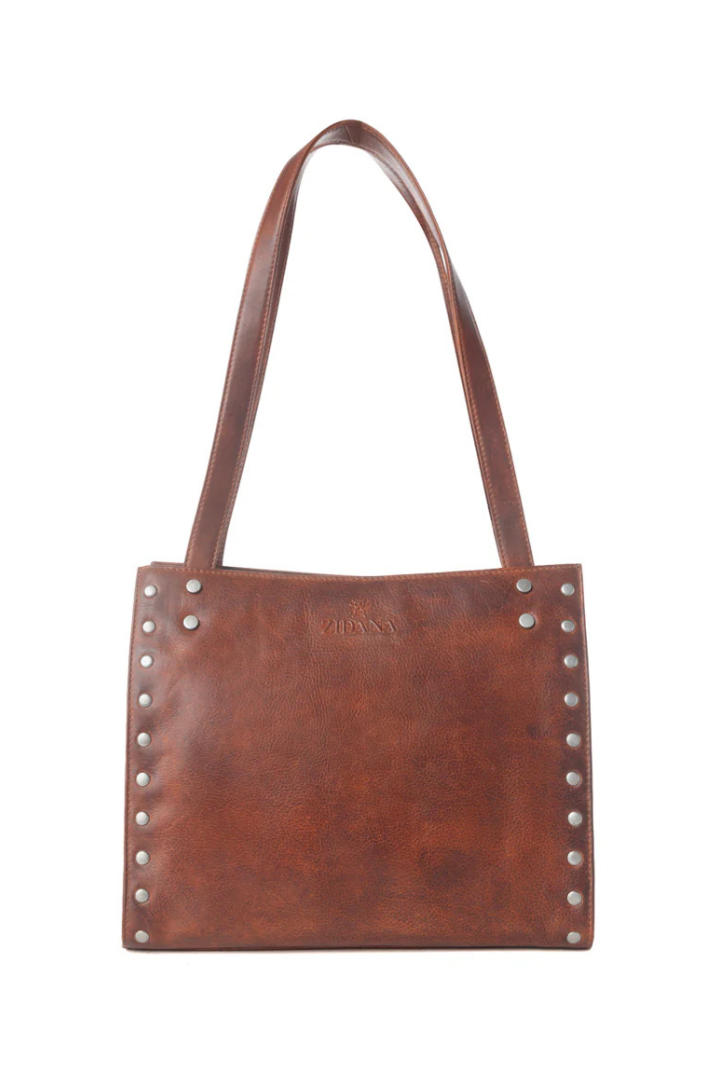 Brown leather tote bag with studs on a white background