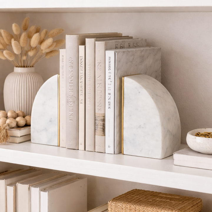 Marble bookends on a shelf with books and decorative items.