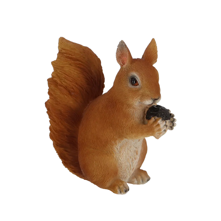 Squirrel figurine holding a nut on a white background