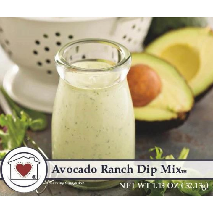 A jar of Avocado Ranch Dip Mix with an avocado and some vegetables in the background.