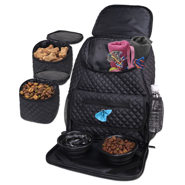 A black quilted dog mom essentials travel backpack with various pet food and accessories organized inside it, including a bowl, a bottle, and socks.